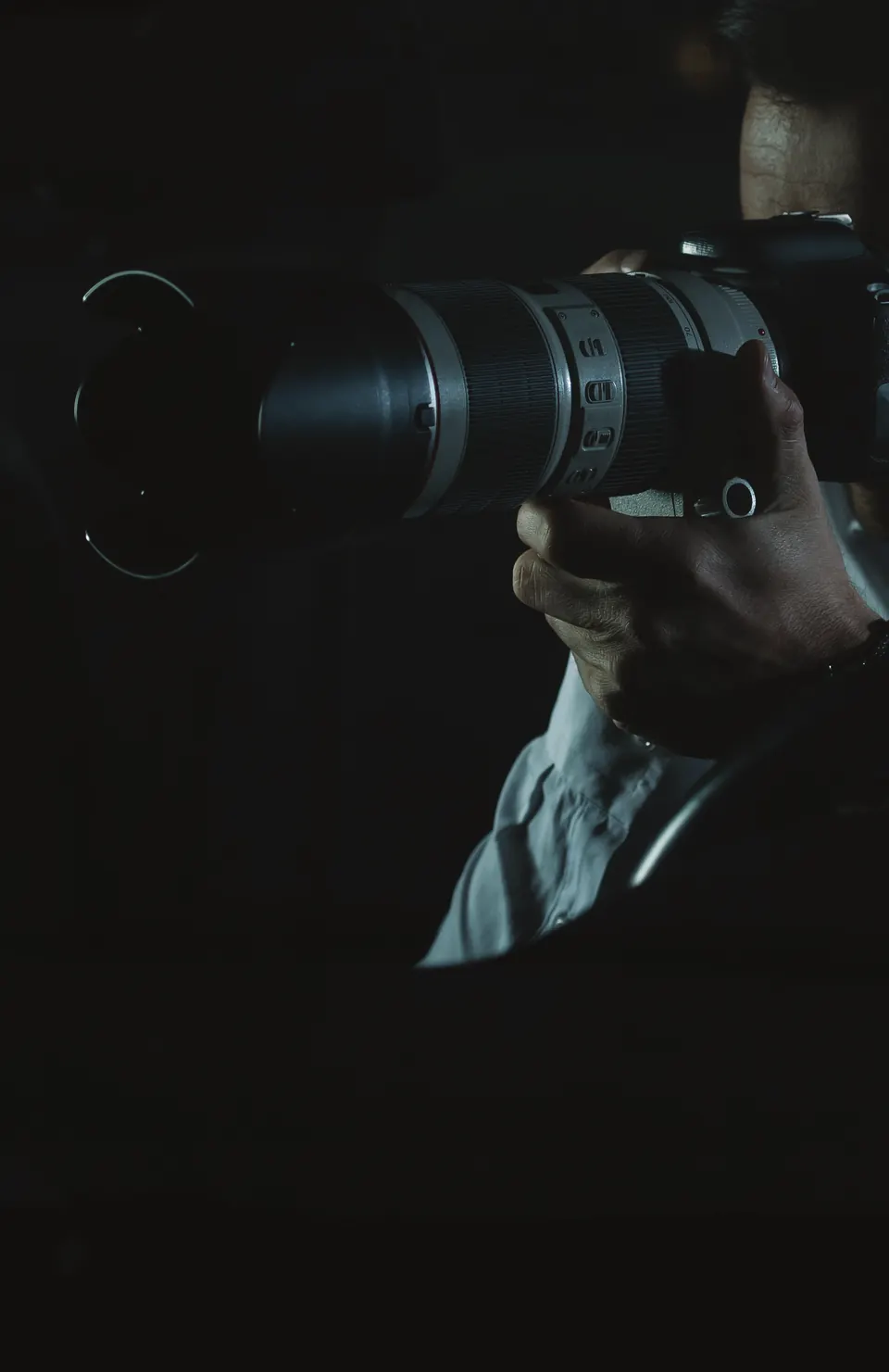 Person holding a camera with a long lens.